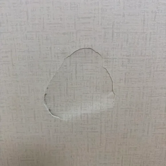 벽지 표면이 둥글게 벗겨진 파손 현장